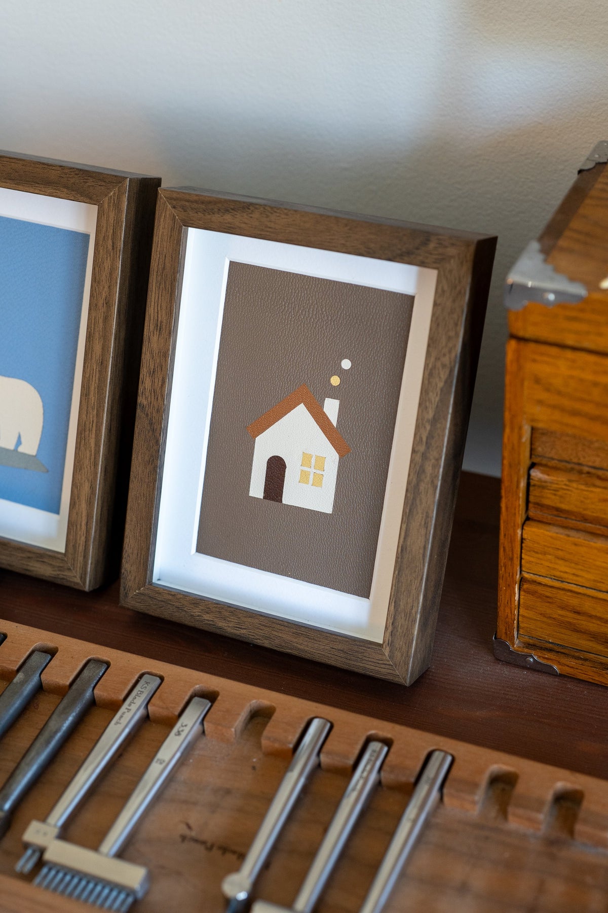 Angled view of the framed Warm Home leather art showing the leather grain