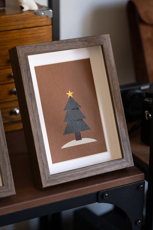 Christmas Tree leather art in a walnut frame, a green tree with a gold star on tan leather
