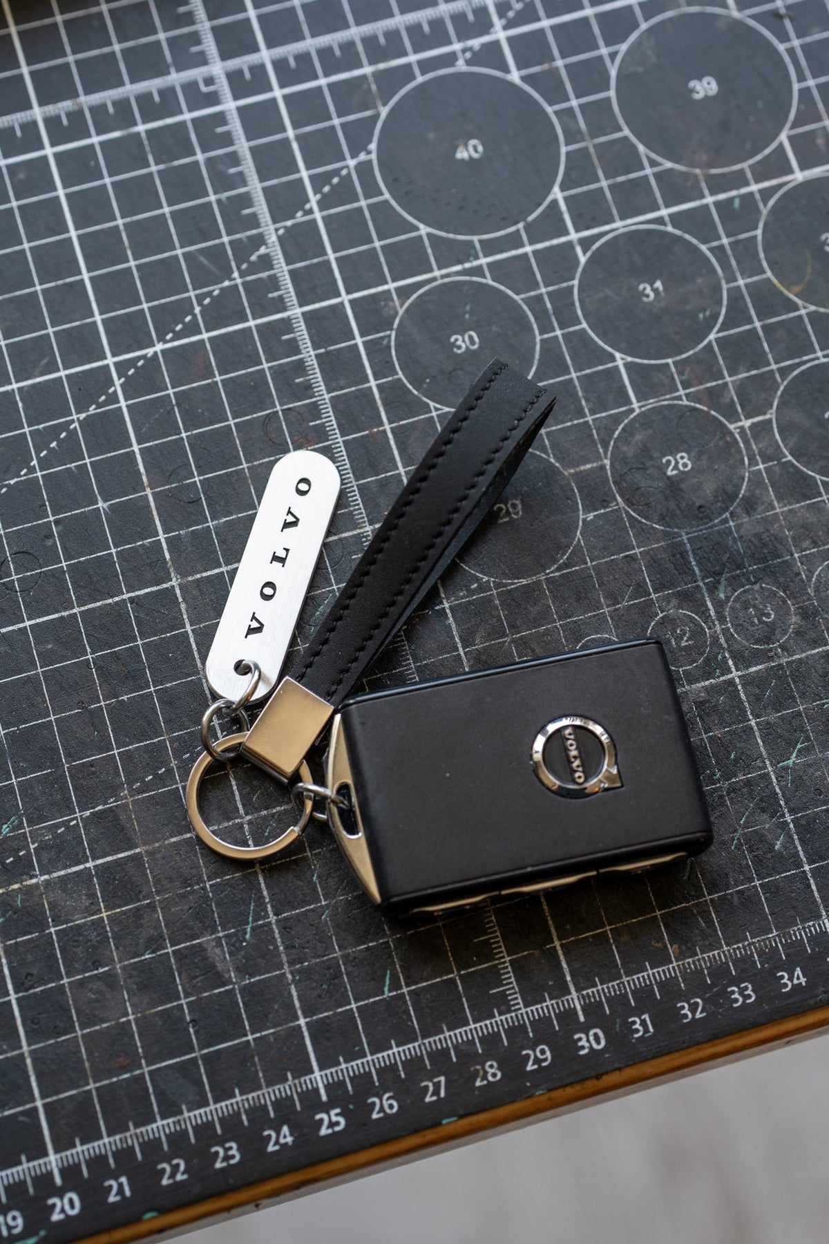 Hand-stitched Volvo leather keychain with engraved stainless steel tag on a Volvo car key